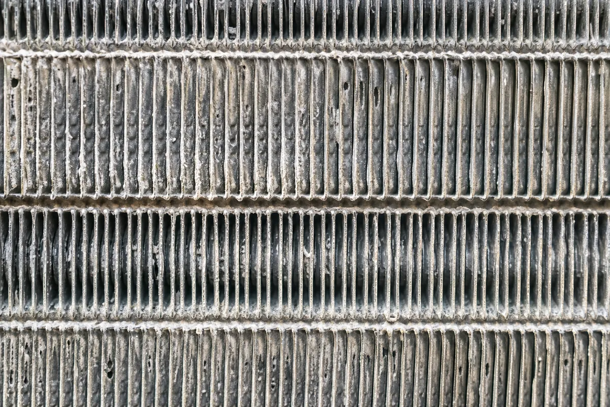 Ailettes d’un échangeur de pompe à chaleur marquées par le sel et la corrosion en zone littorale